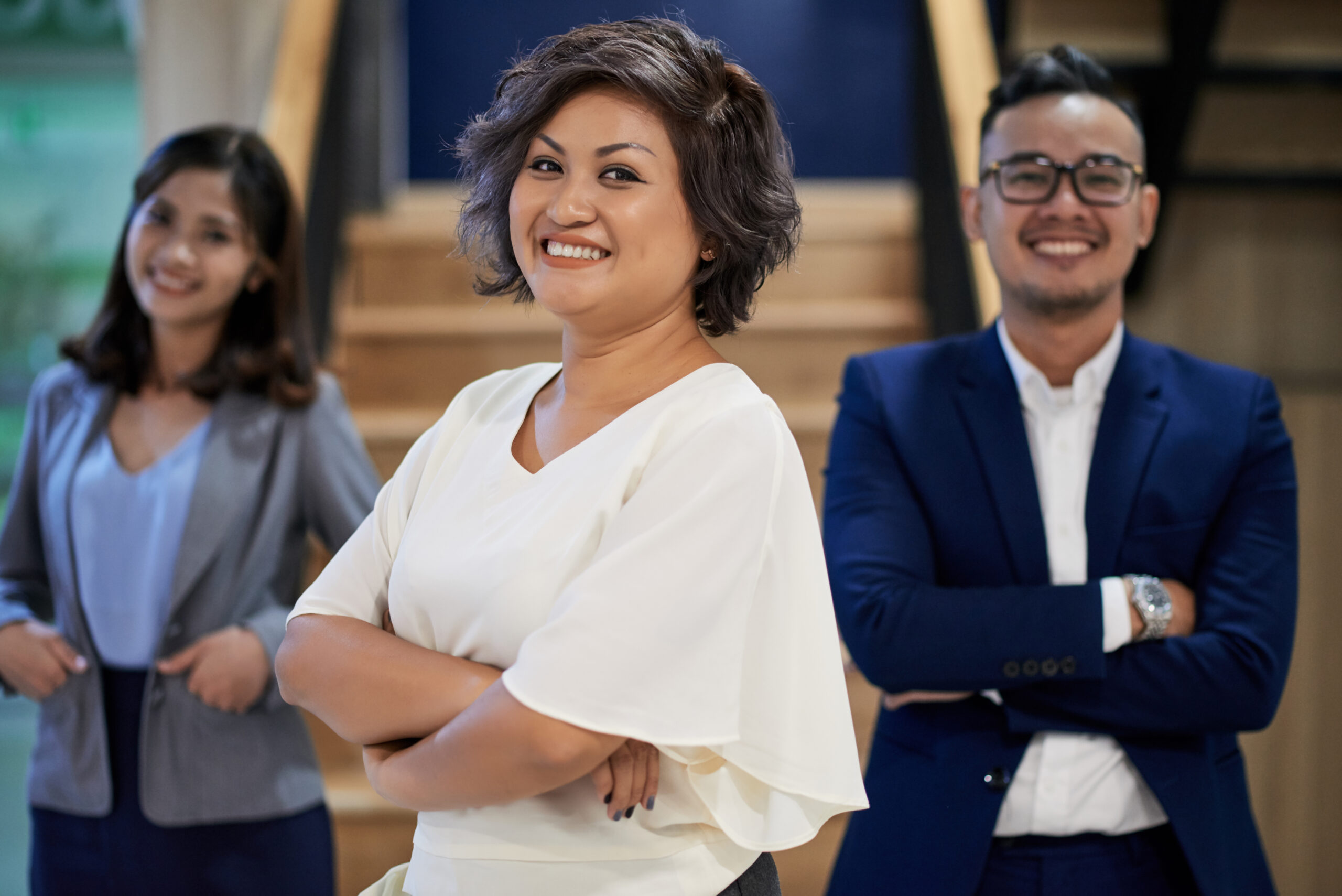 Smiling business leader standing with her team in an office